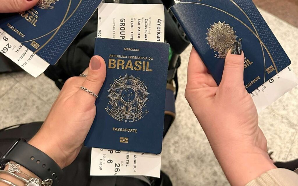 Três mãos segurando seus respectivos passaportes durante viagem para Miami